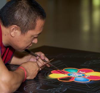 One of the monks works on the Sand Mandala